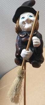 Hexe auf Stab, beide Hände am Besen
