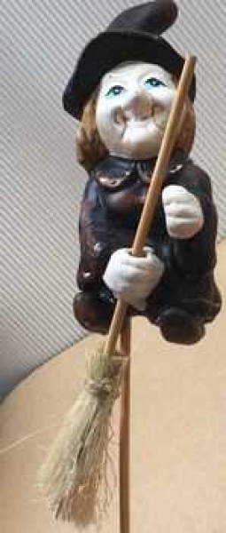 Hexe auf Stab, beide Hände am Besen